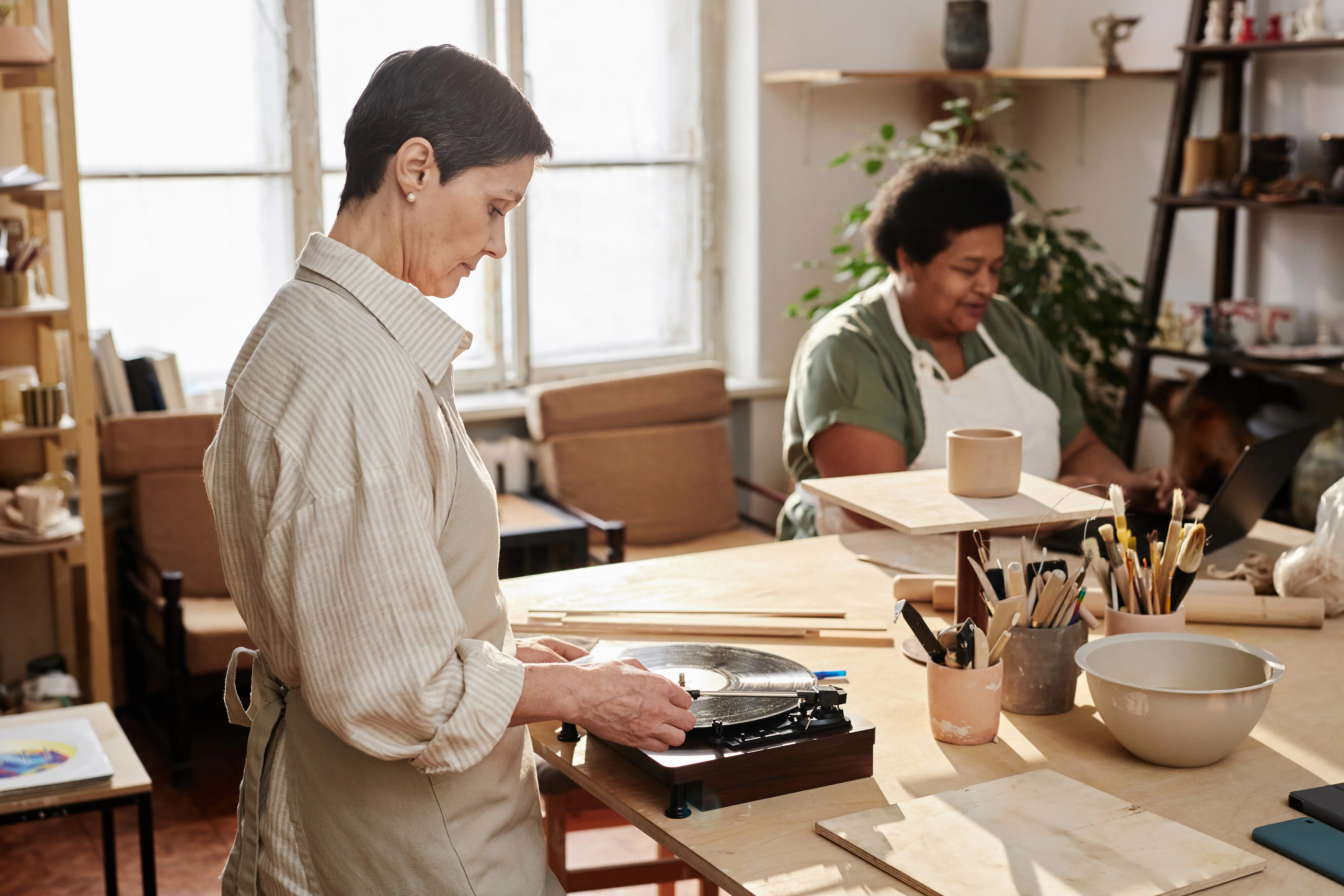 Eine Seniorin spielt Musik in einem Kunststudio.