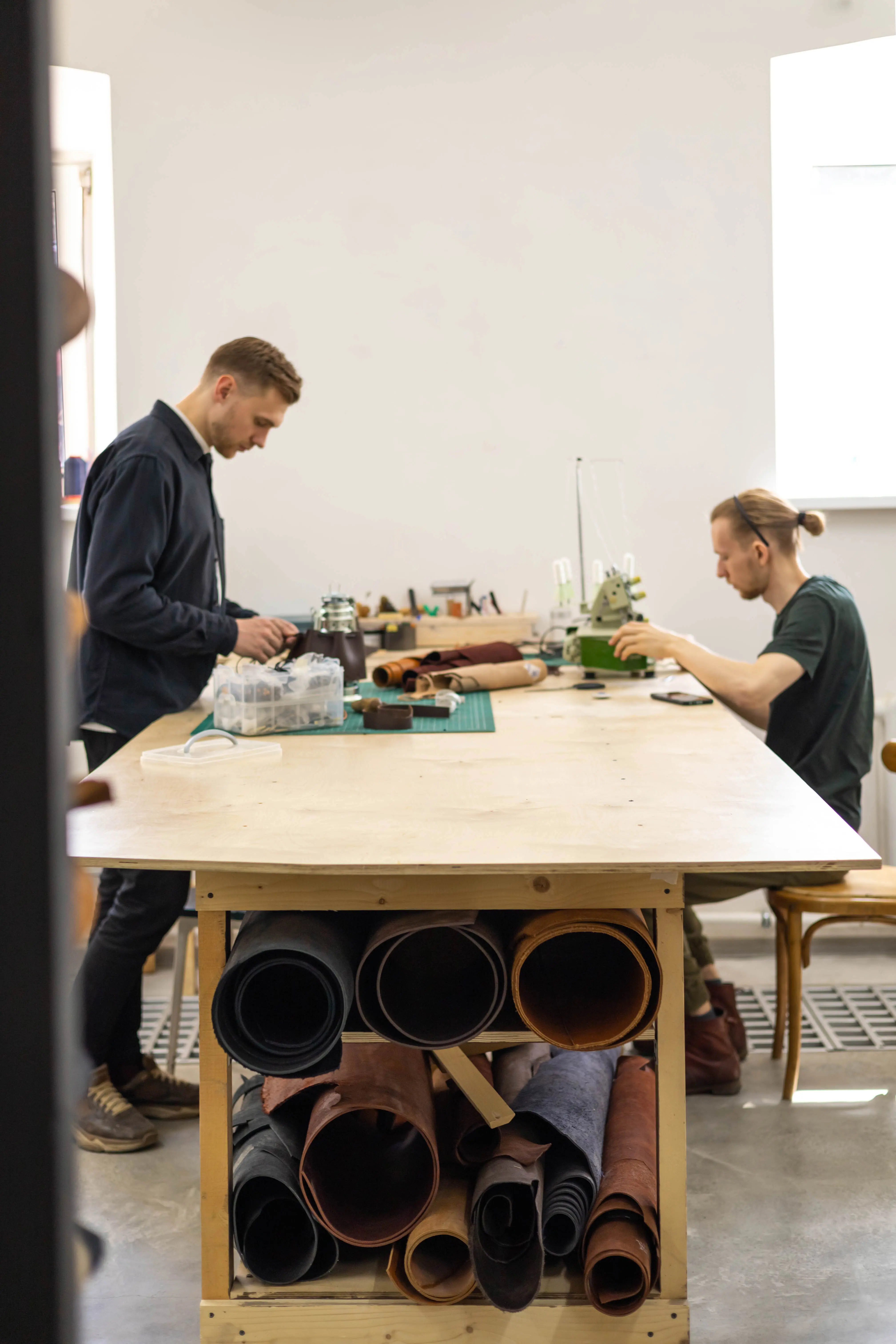 Seitenansicht eines Mannes, der in einem Café ein Handy benutzt.